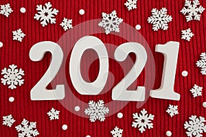 White wooden numbers 2021 and Christmas decorations on red knitted background. Top view. Flat lay