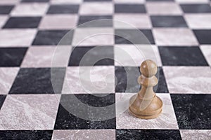 White wooden pawn on chessboard