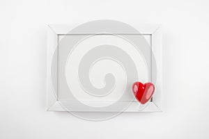 white wooden photo frame and heart on white background