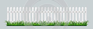 White wooden picket fence with green grass