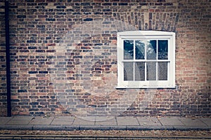 White wooden sash window on a restored brick wall