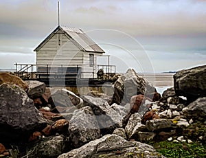 White wooden shed on dockyard on the rocks.