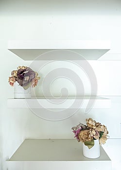 White Wooden Shelf with Vintage Style Flowerpots on White Wall photo