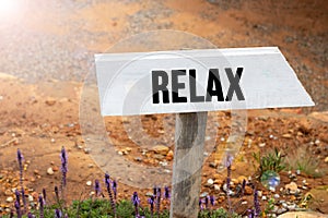 White wooden signpost with the word relax