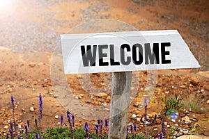 White wooden signpost with the word welcome
