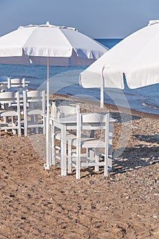 White wooden table on beach with blue sea with two chair