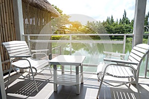 White wooden table and chairs are located on terrace of house an