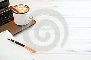 White wooden table with  pen, notebook and  cocoa copy space cinnamon