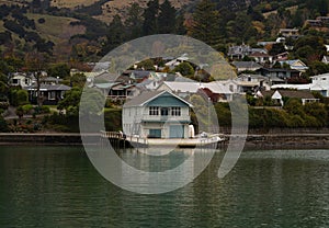 White wooden waterfront boat house built on stilts historic architecture, French Bay Akaroa Banks Peninsula New Zealand