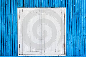 White wooden window on blue bamboo wall