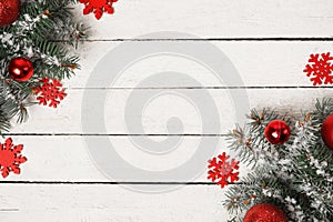 White wooden winter Christmas background with fir tree, red decorations and snow, copy space