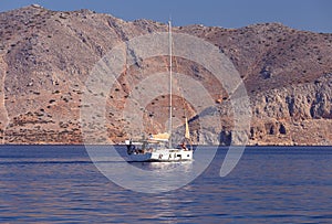 White yacht against the backdrop of high mountains in the bay of Symi island