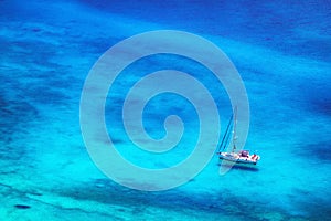 White yacht in azure blue bay with crystal clear water