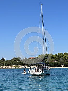 White yacht in the bay of the Adriatic Sea. Holidays on the open sea on a small boat. Boat with a sail near the sea coast