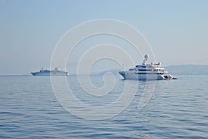 White yacht and a cruiser on the sea nearby Corfu