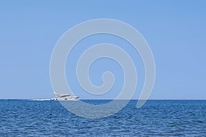 White yacht sailing on sea in clear sunny day, side view.