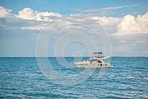 White yacht sails on the Caribbean sea, the sky is cloudy.