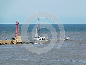 A white yacht and a small boat next to the pier