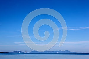 White yacht traveling at sea against a blue sky