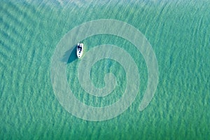 White yacht and turquoise water waves from top view