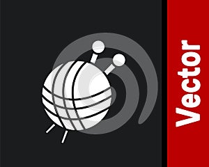 White Yarn ball with knitting needles icon isolated on black background. Label for hand made, knitting or tailor shop