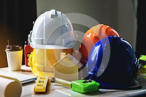 White, yellow and blue safety helmets for workers` safety projects in the position of engineers and all necessary equipment place