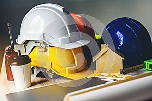White, yellow and blue safety helmets for workers` safety projects in the position of engineers and all necessary equipment place