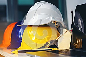 White, yellow and blue safety helmets for workers` safety projects in the position of engineers and all necessary equipment place