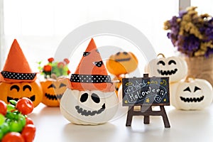 White and yellow ghost pumpkins with witch hat