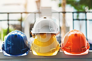 White, yellow and other colored safety helmets for workers` safety projects in the position of engineers or workers on concrete