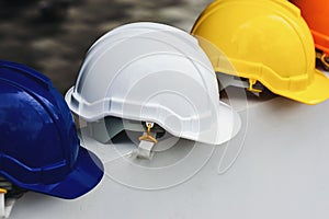 White, yellow and other colored safety helmets for workers` safety projects in the position of engineers or workers on concrete