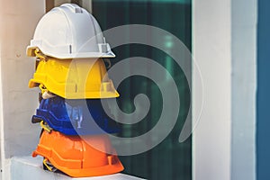 White, yellow and other colored safety helmets for workers` safety projects in the position of engineers or workers on concrete