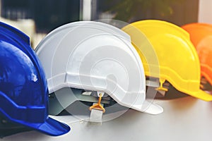 White, yellow and other colored safety helmets for workers` safety projects in the position of engineers or workers on concrete