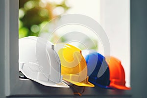 White, yellow and other colored safety helmets for workers` safety projects in the position of engineers or workers on concrete