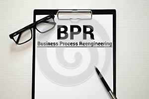 white and yellow paper with text BPR Business process reengineering on a white background with stationery