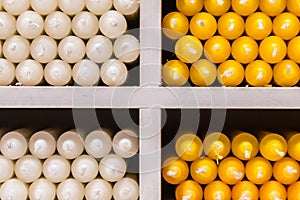 White and yellow candles on shelves in shop