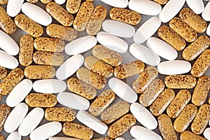 White and yellow pills as background