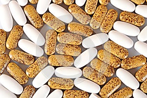 White and yellow pills as background