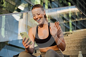 White young woman gesturing and using mobile phone after yoga practice