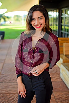 White young woman wearing a casual outfit posing for the camera at the cafe, vertical