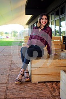 White young woman wearing a casual outfit posing for the camera at the cafe, vertical