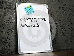 A whiteboard near the wall with words competitive analysis.