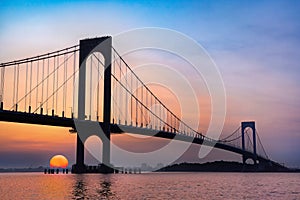 Whitestone Bridge in Queens, New York City at sunset with the water of the Long Island Sound in view.