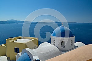 Whitewashed architecture with a distinctive blue dome characterizes the scene in Santorini, Greece.