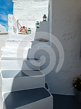 Whitewashed building empty narrow stone stairs at Kimolos island Greece. Vertical photo