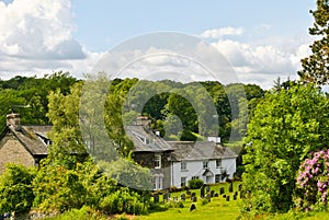 Whitewashed cottage in woodland setting.