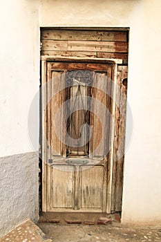 Whitewashed facade with old wooden door in Altea