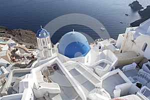 Whitewashed houses and blue dome church by the Aegean sea, Santoriniin Oia, Santorini, Greece. Famous blue domes in Oia village,