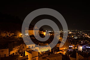 Whitewashed Houses and Cityscape in Granada, Spain as seen from Barranco del Abogado at Night photo