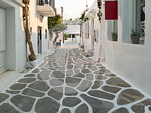 Whitewashed houses empty cobblestone alley at Naousa village, Paros island, Greece